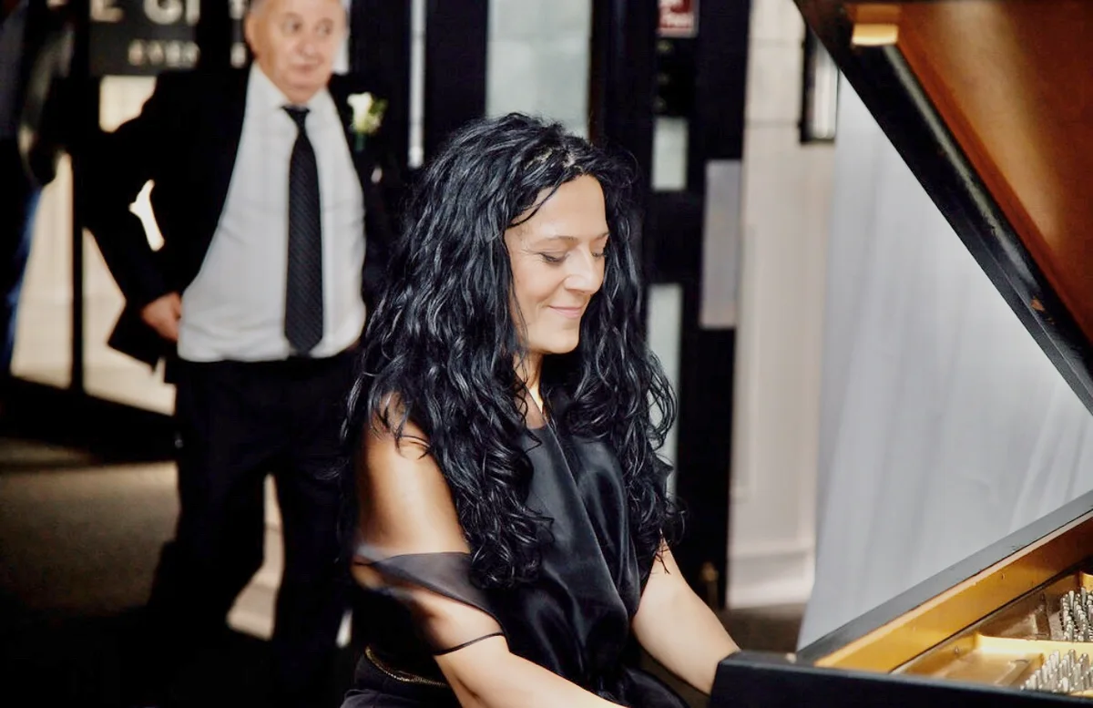 Anahit at the piano, smiling